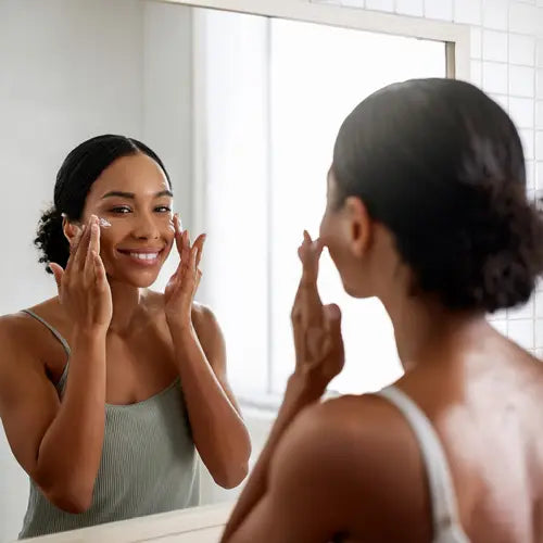 Une femme applique de la crème anti-âge bio sur sa peau. 